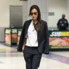 Victoria Beckham, ultrachic en costume noir, chemise blanche et souliers Manolo Casadei à son arrivée à l'aéroport JFK. New York, le 24 septembre 2014.