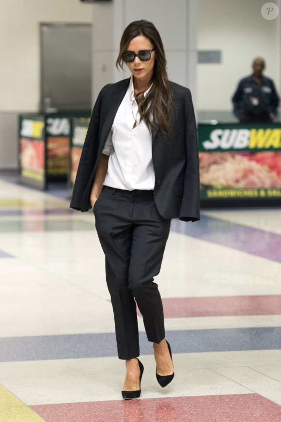 Victoria Beckham, ultrachic en costume noir, chemise blanche et souliers Manolo Casadei à son arrivée à l'aéroport JFK. New York, le 24 septembre 2014.