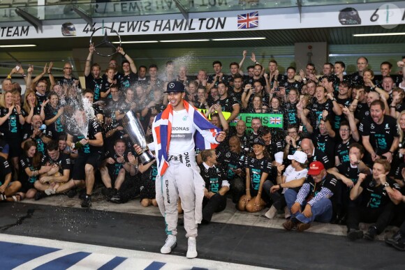 Lewis Hamilton célèbre son titre de champion du monde devant son écurie et Nicole Scherzinger, le 23 novembre 2014 à Abou Dhabi