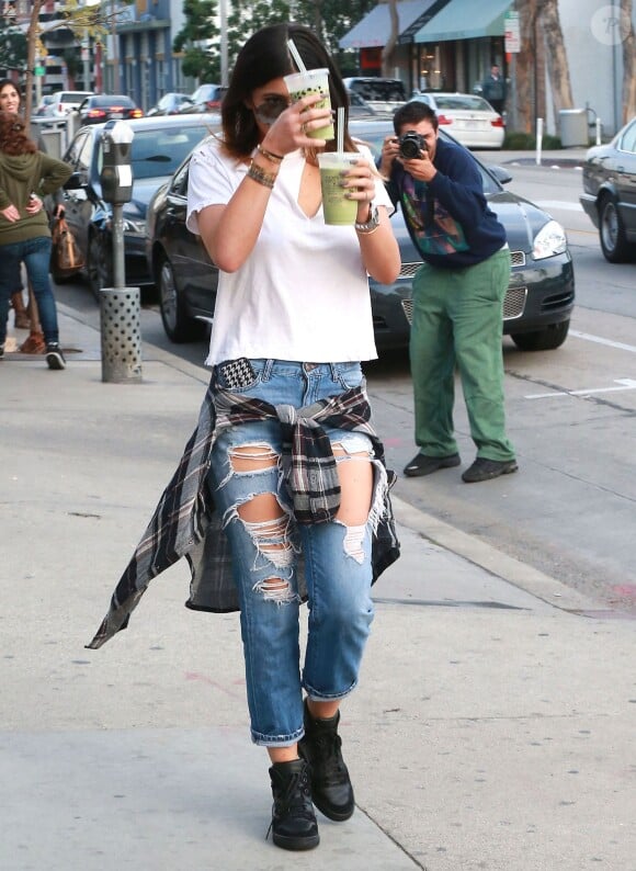 Kylie Jenner, de sortie à West Hollywood dans un top blanc, une chemise à carreaux nouée à la taille, un jean destroy et des baskets Balenciaga. Le 9 février 2014.