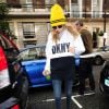 Cara Delevingne porte un bonnet jaune de sa collection CaraD4DKNY pour DKNY, un pull DKNY, un jean et des bottines Timberland. Londres, le 8 octobre 2014.