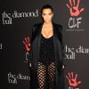 Kim Kardashian, habillée d'un manteau, d'une robe et d'un body Balenciaga (collection printemps-été 2015) et chaussée de sandales Tom Ford, assiste au Diamond Ball de la Clara Lional Foundation. Beverly Hills, le 11 décembre 2014.