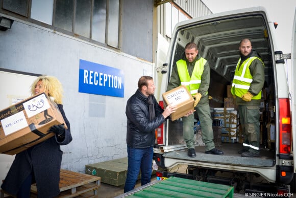 Alain Bernard participe au chargement de la tonne de dons à la base aérienne 123 d'Orléans. Le 11 décembre 2014.