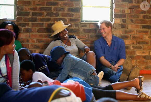 Le prince Harry dans un centre pour orphelins porteurs du VIH le 9 décembre 2014 lors de sa visite privée pour suivre les actions de son association Sentebale.