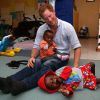 Le prince Harry avec des enfants suivant un programme contre la malnutrition à Maseru, le 8 décembre 2014 lors de sa visite privée pour suivre les actions de son association Sentebale.