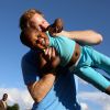 Le prince Harry soulève le jeune orphelin Lerato tandis que la petite non-voyante Karabo prend la photo, le 6 décembre 2014 dans un orphelinat de Maseru, lors de sa visite privée pour suivre les actions de son association Sentebale.