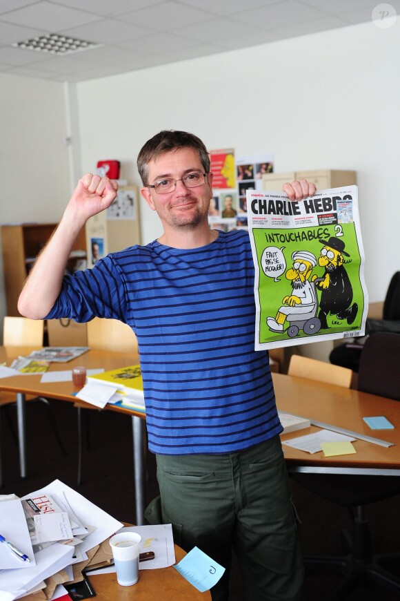 Charb avec l'une des plus célèbre couvertures de Charlie Hebdo, à Paris, le 19 septembre 2012.