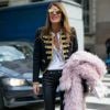 Anna Dello Russo quitte le défilé John Richmond à Milan, habillée d'une veste et d'un pantalon en cuir Saint Laurent, d'une chemise blanche et de sandales Isabel Marant. Elle tient à la main un manteau en fourrure rose pâle N°21. Le 18 janvier 2015. 