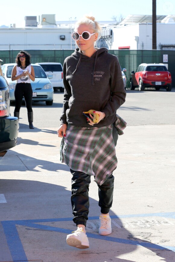 Gwen Stefani arrive dans un studio de danse à Los Angeles, habillée d'un pull Hanser Surfboards, d'un pantalon en cuir, d'une chemise à carreaux nouée à la taille et de baskets adidas Originals (modèle Pharrell Williams Stan Smith). Le 17 janvier 2015.