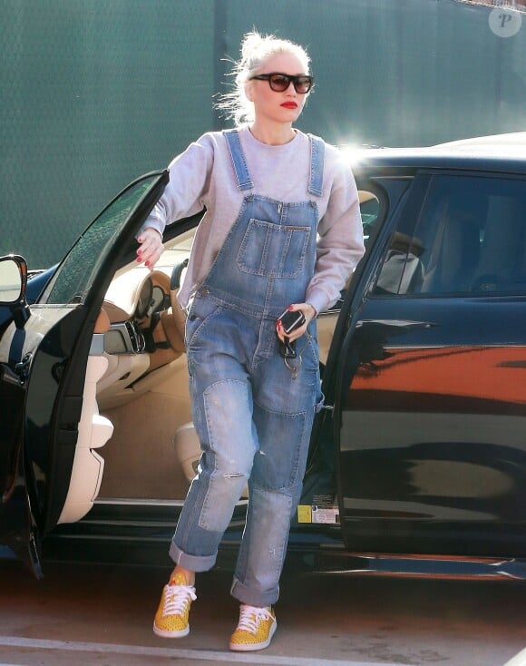 Gwen Stefani se rend dans un studio à Burbank, habillée d'une salopette en denim, d'un pull gris et de baskets à pois adidas Originals (modèle Pharrell Stan Smith). Le 18 janvier 2015.