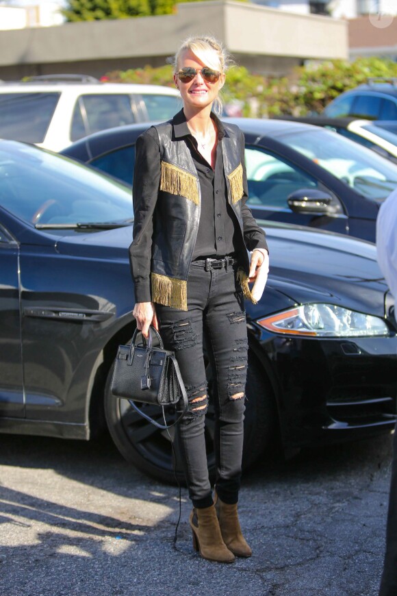 Laeticia Hallyday de sortie à Beverly Hills, porte un gilet à franges, un sac (modèle Nano Sac de Jour), une ceinture (modèle Western) et des bottines Saint Laurent. Le 16 janvier 2015.