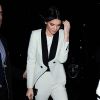 Kendall Jenner arrive au restaurant Mr Chow à Londres, habillée d'un costume blanc à revers et liserés latéraux noirs Emilio Pucci, et chaussée de sandales Giuseppe Zanotti. Le 22 février 2015.