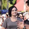 Demi Lovato se rend, accompagnée de son petit caniche blanc, à l'émission "Extra" de Mario Lopez pour une interview à Universal City, le 3 mars 2015 