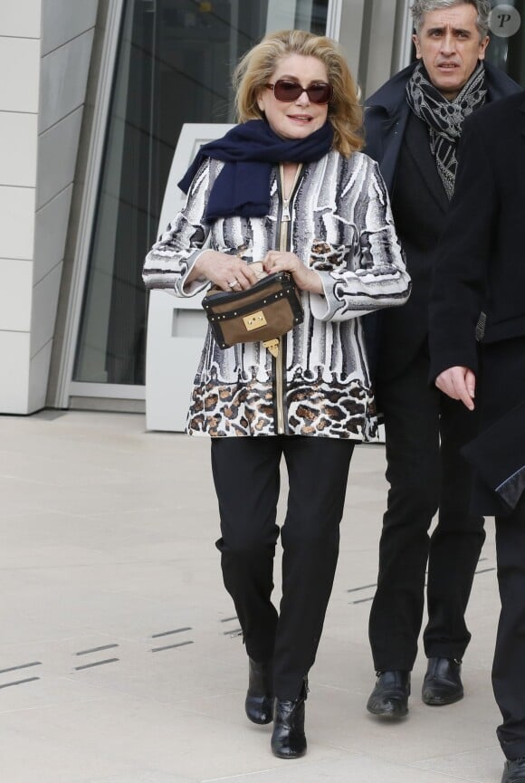 Catherine Deneuve quitte la Fondation Louis Vuitton à l'issue du défilé Louis Vuitton automne-hiver 2015-2016. Paris, le 11 mars 2015.