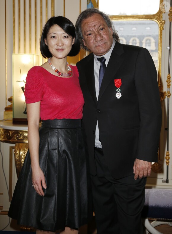 Tony Gatlif pose avec la Ministre de la Culture Fleur Pellerin lors de la cérémonie le décorant Chevalier de l'ordre national de la Légion d'honneur au Ministère de la Culture à Paris, le 30 mars 2015