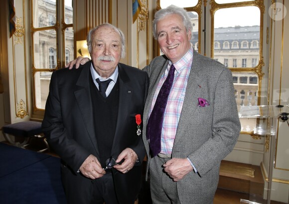 Jean Becker pose avec Jean-Loup Dabadie lors de la cérémonie le décorant de Officier de l'ordre national de la Légion d’honneur au Ministère de la Culture à Paris, le 30 mars 2015