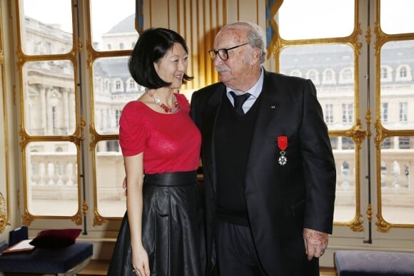 Jean Becker pose avec la Ministre de la Culture Fleur Pellerin lors de la cérémonie le décorant de Officier de l'ordre national de la Légion d'honneur au Ministère de la Culture à Paris, le 30 mars 2015