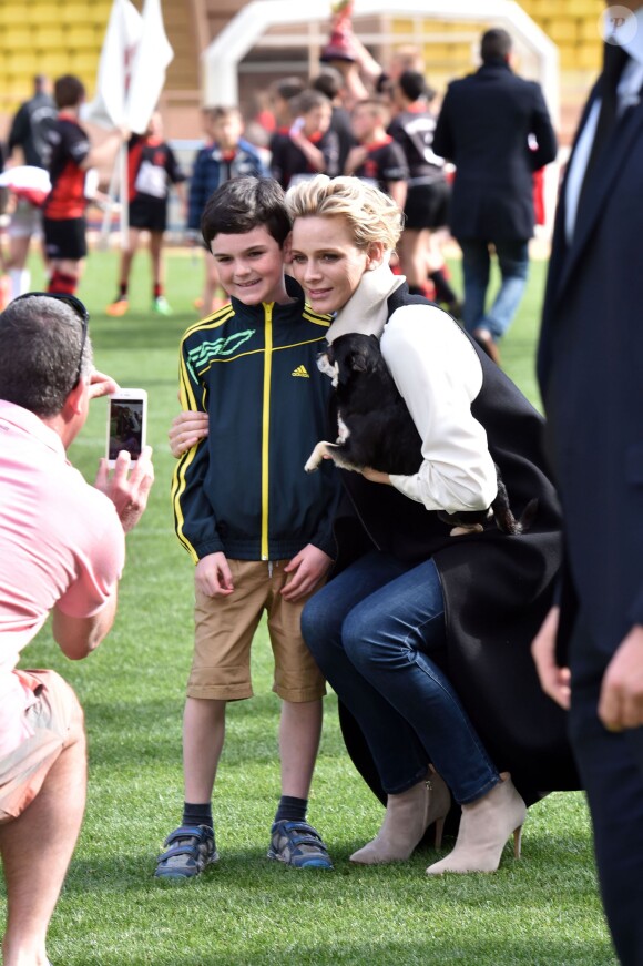La princesse Charlene de Monaco, son petit chihuahua "Monte" et un enfant participant à la 5e édition du "Tournoi Sainte-Dévote" le samedi 11 avril 2015, au Stade Louis II de Monaco