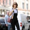 Taylor Swift à New York, porte un sac bordeaux Gucci (modèle Jackie) et des lunettes Westward Leaning pour accessoiriser sa tenue noire et blanche, composée d'un top court, d'une salopette et de bottines en cuir. Le 28 mai 2015.