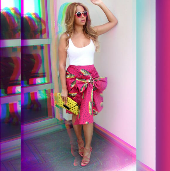 Beyoncé porte des lunettes de soleil Quay, un débardeur blanc, une jupe Stella Jean (modèle Dugongo, collection printemps-été 2015), un sac Milli Millu et des sandales Alaïa. Mai 2015.