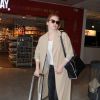 Emma Stone arrive à l'aéroport de Nice, habillée d'un manteau COS, d'un t-shirt henley J Brand, d'un jean noir et de baskets adidas (modèle Superstar). Le 16 mai 2015.