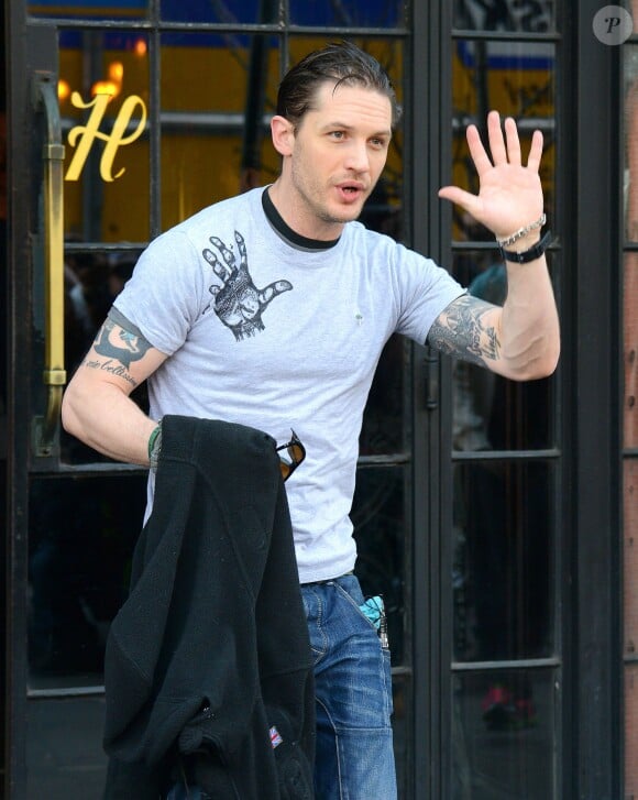 Tom Hardy salue ses fans et photographes qui l'attendent à la sortie de son hôtel à New York le 22 avril 2014.