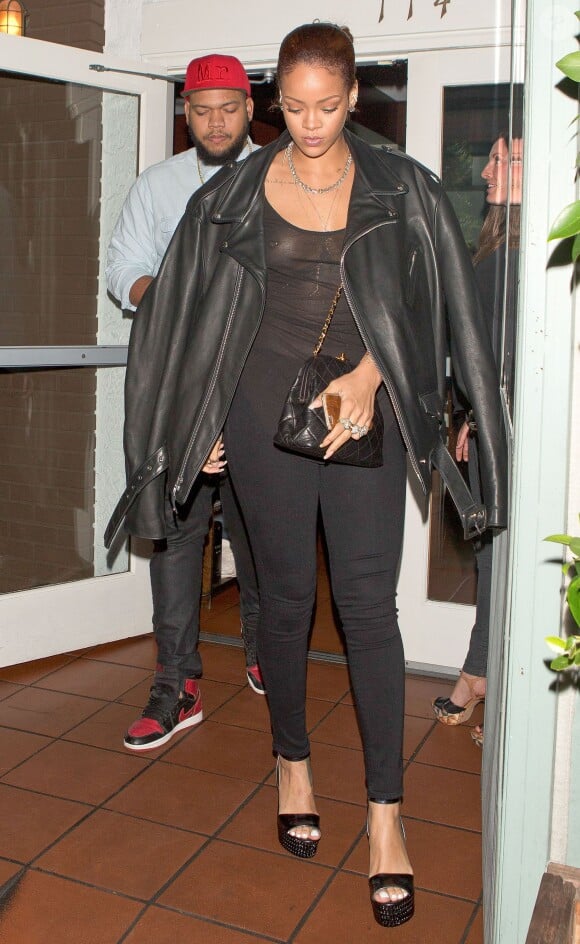 Rihanna, tout de noir vêtue, quitte le restaurant Giorgio Baldi avec son frère Rorrey Fenty. Santa Monica, Los Angeles, le 30 juin 2015.