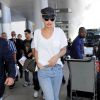 Rita Ora prend un vol à l'aéroport LAX de Los Angeles, habillée d'un t-shirt blanc, d'un jean et de baskets adidas (modèle Superstar). Le 2 juillet 2015.