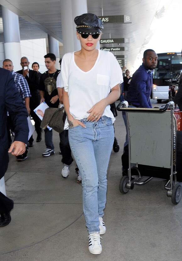 Rita Ora prend un vol à l'aéroport LAX de Los Angeles, habillée d'un t-shirt blanc, d'un jean et de baskets adidas (modèle Superstar). Le 2 juillet 2015.