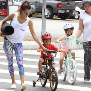 Alessandra Ambrosio et ses deux enfants Anja et Noah à vélo, se baladent dans le quartier de Brentwood. Los Angeles, le 18 juillet 2015.