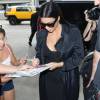 Kim Kardashian (enceinte) signe des autographes en arrivant à l'aéroport LAX de Los Angeles pour prendre un avion. Le 19 juillet 2015