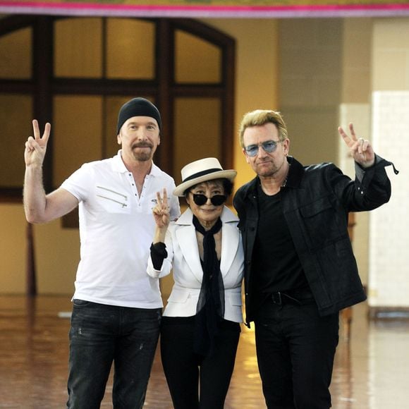 The Edge, Yoko Ono et le chanteur Bono - Une tapisserie rendant hommage à John Lennon dévoilée Elis Island, en face de Manhat­tan à New York, le 29 juillet 2015. Il y a 40 ans, John Lennon rece­vait sa Green Card, pour célébrer cet évènement une tapis­se­rie a été comman­dée par le fonda­teur de Art for Amnesty pour remer­cier Yoko Ono d'avoir cédé à Amnesty Inter­na­tio­nal les droits sur les reprises des chan­sons que Lennon a compo­sées dans la période post-Beatles.