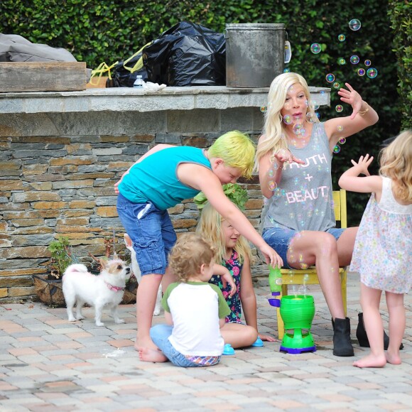 Tori Spelling s'amuse avec ses quatre enfants dans le jardin de sa maison à Los Angeles, le 28 juillet 2015