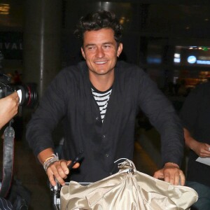 Orlando Bloom, tout souriant à son arrivée à l'aéroport de LAX à Los Angeles, le 1er août 2015 en provenance de Londres où il a assisté au mariage de Guy Ritchie.