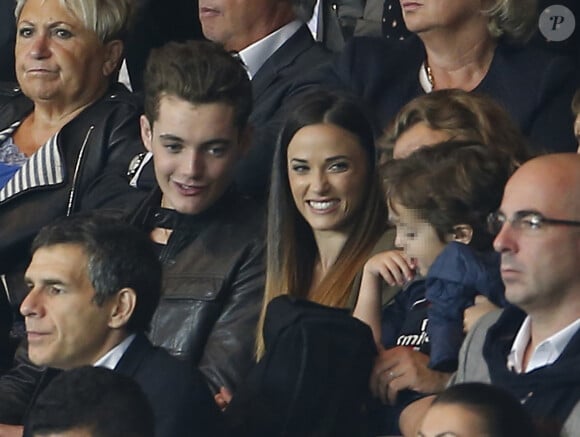 Louis Sarkozy et Capucine Anav avec le jeune Solal Sarkozy, fils de Jean, le 16 août 2015 au Parc des Princes lors de la victoire du PSG contre le GFC Ajaccio.