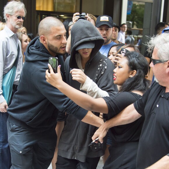 Justin Bieber, assailli par ses fans, se promène avec ses gardes du corps dans les rues de Manhattan à New York. Le 24 août 2015