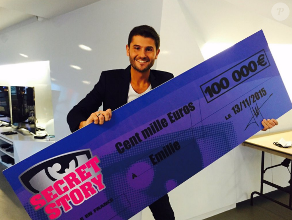 Christophe Beaugrand pose avec le chèque de 100 000 euros destiné à Emilie, grande gagnante de Secret Story 9. Le 19 novembre 2015.