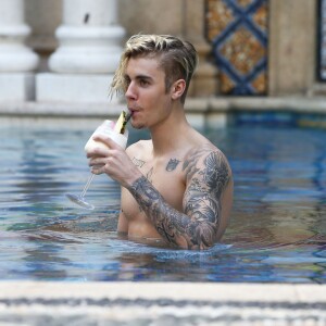 Exclusif - Prix spécial - Justin Bieber se relaxe avec des amis au bord de la piscine de la 'Versace Mansion’ en buvant un cocktail à Miami, le 9 décembre 2015