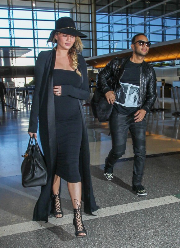 Chrissy Teigen enceinte et son mari John Legend arrivent à l'aéroport de LAX à Los Angeles pour prendre l'avion, le 25 décembre 2015.