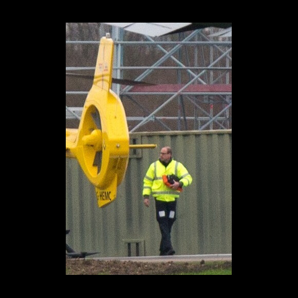 Le prince William en train de faire le plein et d'inspecter son hélicoptère-ambulance le 12 janvier 2016 à l'aéroport de Cambridge, de retour au travail après les fêtes de fin d'année.