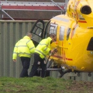 Le prince William en train de faire le plein et d'inspecter son hélicoptère-ambulance le 12 janvier 2016 à l'aéroport de Cambridge, de retour au travail après les fêtes de fin d'année.