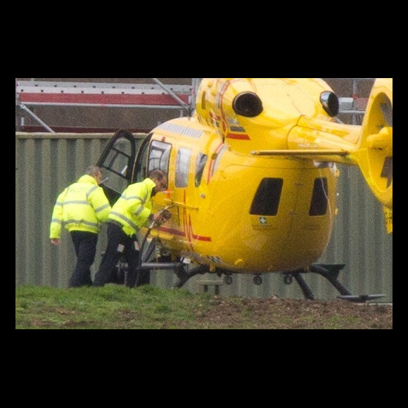 Le prince William en train de faire le plein et d'inspecter son hélicoptère-ambulance le 12 janvier 2016 à l'aéroport de Cambridge, de retour au travail après les fêtes de fin d'année.
