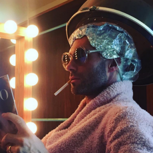 Behati Prinsloo a publié une photo de son mari Adam Levine en train de poser sous un appareil de coiffure, un magazine à la main et des lunettes de soleil sur le nez. Comme une vraie femme ou presque ! Photo publiée sur Instagram, le 18 février 2016.