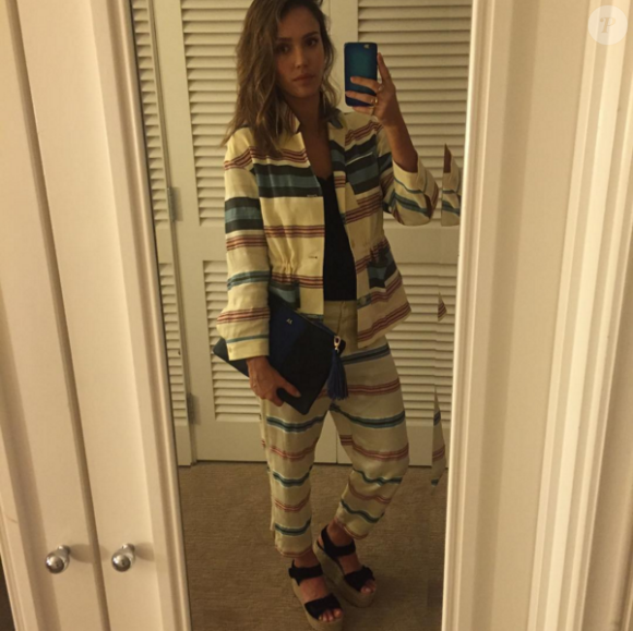 Jessica Alba, en vacances au Mexique et prête à sortir pour dîner, porte un ensemble veste et pantalon en soie H&M Studio (collection printemps-été 2016), une pochette de la collection WhoWearWhat pour Target et des sandales Céline. Photo publiée le 20 mars 2016.