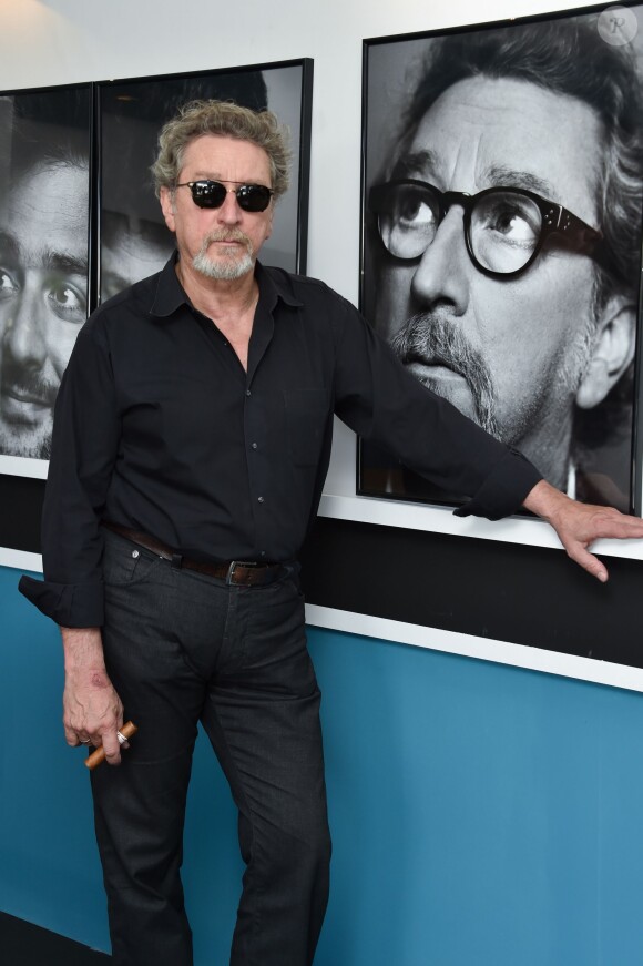 Exclusif - Robert Guediguian pose devant son portrait, réalisé par Matias Indjic, dans les bureaux d'Unifrance Films sur le marché du film lors du 68e festival de Cannesle 20 mai 2015