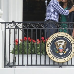 Barack Obama embrasse sa femme Michelle Obama  lors de la traditionnelle chasse aux oeufs de Pâques de la Maison Blanche à Washington, le 28 mars 2016.