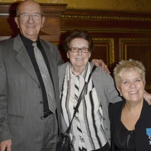 Mimie Mathy, entourée de ses parents Marcel et Roberte, émue après avoir reçu les insignes de Chevalier de l'Ordre National du Mérite des mains de Jean-Claude Camus à l'issue de son spectacle "Je re-papote avec vous" au théâtre de la Porte Saint-Martin à Paris le 13 decembre 2013 