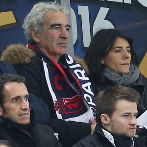 Raymond Domenech et sa compagne Estelle Denis, dans les tribunes de la rencontre finale de la Coupe de la Ligue PSG-Lille au Stade de France à Paris, le 23 avril 2016.