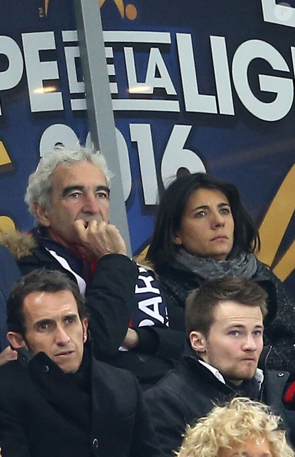 Raymond Domenech et sa compagne Estelle Denis, dans les tribunes de la rencontre finale de la Coupe de la Ligue PSG-Lille au Stade de France à Paris, le 23 avril 2016.