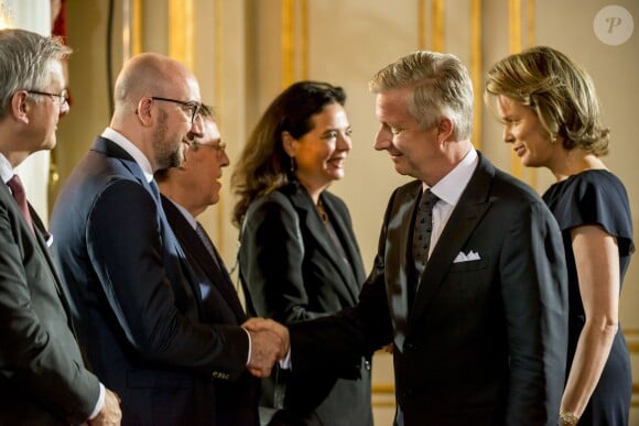Le roi Philippe de Belgique, qui salue ici le Premier ministre Charles Michel, et la reine Mathilde de Belgique présidaient le 22 mai 2016 au palais royal à Bruxelles une cérémonie d'hommage aux victimes des attentats terroristes perpétrés le 22 mars 2016.